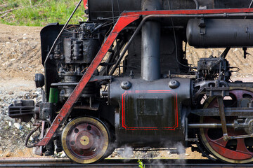 Close-up of part of an old black steam locomotive