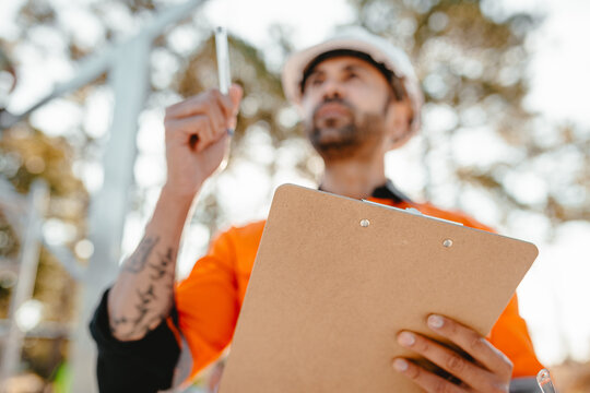 Close-up of a clipboard held by a man out of focus in background.