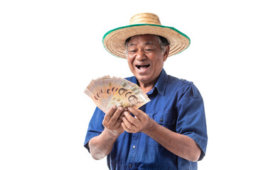 Fototapeta premium Happy smiling of elderly Asian farmer man wear a hat holding Thai banknotes money isolated on white background.