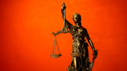 statue of Themis, the Greek goddess of justice on a red background. concept of justice