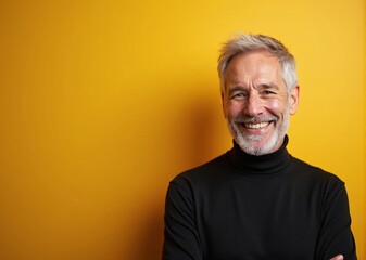 Obraz premium Cheerful senior man smiling confidently against vibrant yellow background with copy space