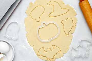 Making different shapes of fall cookies for Halloween. Dough with cookie cutter