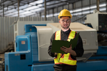 Male engineer control CNC machine in factory. Male technician working and repairing or maintenance CNC machine with safety uniform, helmet in industry factory