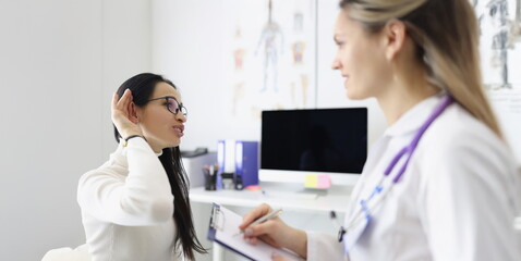 Portrait of client complain on pain in ear and doctor check patients ear on medical examination....