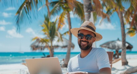 Young man working with laptop computer on the beach
