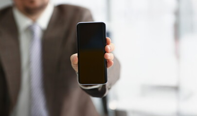 Close-up of male arm in suit show in camera mobile phone display with black screen. Broken or locked smartphone, not working. Mockup, copy space concept