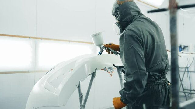 Techniques for spray painting a car bumper in a professional workshop setting
