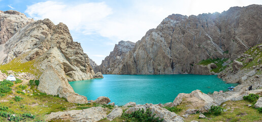 The image shows a blue azure lake surrounded by dark rocks