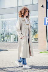 Obraz premium Vertical photo of stunning cheerful girl wear stylish beige trench spring season sunny weather outdoors