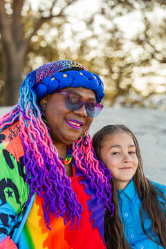 Torres Strait Islander nine year old boy with long hair sitting beside grandmother on the beach