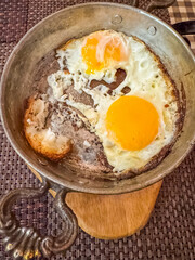 Slightly burnt fried egg in a vintage metal frying pan . High quality photo