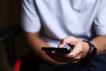 Male hands using a smartphone or tablet in a room. Holding hands. Black background. Home office. For work. for social media or looking for information.