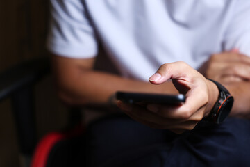 Male hands using a smartphone or tablet in a room. Holding hands. Black background. Home office. For work. for social media or looking for information.