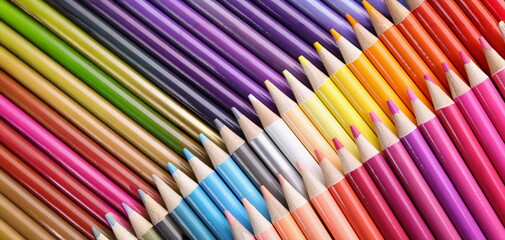 Fototapeta premium Top view of big assortment of colourful pencils placed over each other. Sharp tips of crayons, ready to paint, bright palette. Hobby, creativity concept