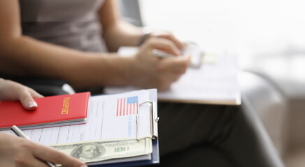 Close-up of person sitting in line with visa application forms to get access to enter country....