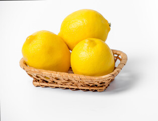 Three lemons in a basket on a white background