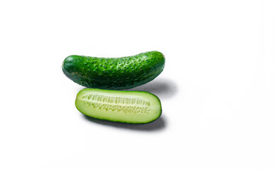 Three cucumbers are cut in half and placed on a white background. The cucumbers are fresh and green, and they are arranged in a way that makes them look like they are ready to be eaten
