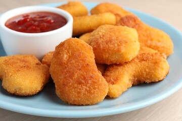 Tasty chicken nuggets with chili sauce on table, closeup