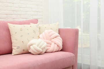 Soft decorative pillows on pink sofa indoors