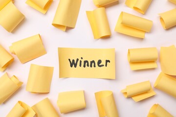 Paper note with word Winner among blank ones on white background, flat lay