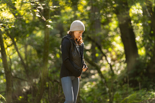 Sporty woman zipping up her jacket before training outdoors, Autumn, fall fitness concept