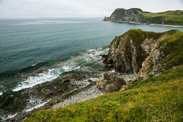 A stunning cliff above the ocean with waves crashing against it