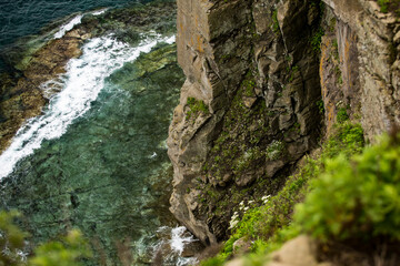 A breathtaking view of a steep cliff that overlooks a vast body of water