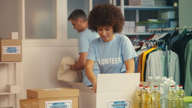 Multiethnic volunteers sorting and packing goods into donation boxes, charity