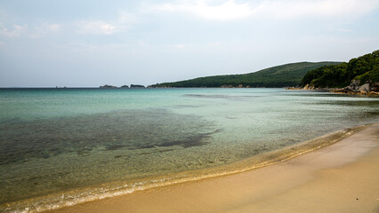 A large body of water with a sandy beach in the foreground