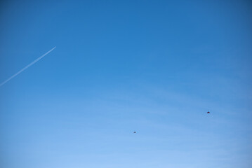 An airplane and a kite soaring together in the sky