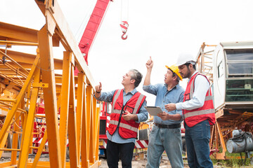 Team of workers at construction site with heavy machines.