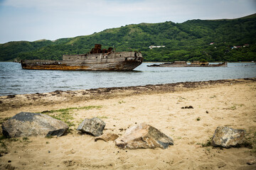 A shipwreck remains, stranded in the center of a vast body of water