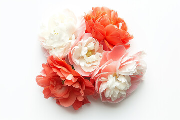 A beautiful arrangement of artificial flowers in shades of red, coral, and white. The flowers are lush and full, showcasing a variety of petals and textures, set against a clean white background.