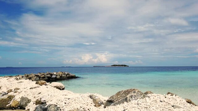 Maldives, watching the Island across the turquoise blue water into the Indian Ocean, from the white sandy Corel sand band. 
