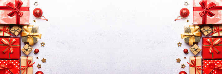 Long wide banner with set of bright gift boxes and Christmas decorations on light concrete background top view, copy space for your design.