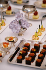 Elegant banquet table featuring assorted gourmet appetizers and a decorative floral centerpiece during a special event