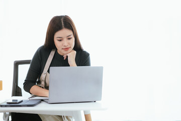 An Asian woman who found success in her e-commerce business, checking orders from a warehouse on her laptop, surrounded by boxes and inventory, fueling the growth of her small startup.