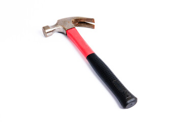 Close up medium sized hammer that has two functions as a nail pick and nail hammer, with a handle covered in black and red rubber isolated on a white background. Little bit rusty