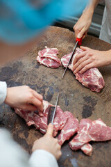 Close shot for slicing and preparing meat with knives, no face
