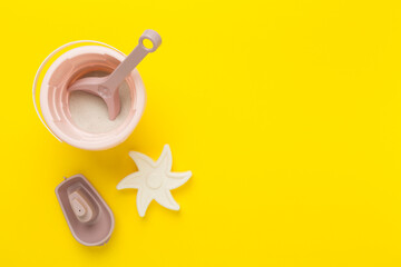 Cute toys for playing with sand on color background, top view