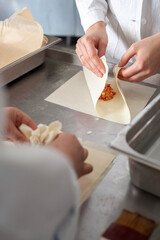 Close shot for preparing filo pastry pouches in restaurant kitchen, no face