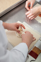 Close shot for preparing filo pastry pouches in restaurant kitchen, no face