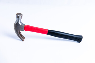 Close up medium sized hammer that has two functions as a nail pick and nail hammer, with a handle covered in black and red rubber isolated on a white background. Little bit rusty