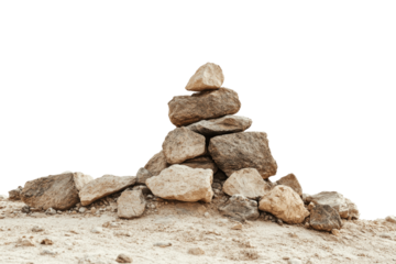 A pile of rocks stacked on a sandy desert landscape with a green background.