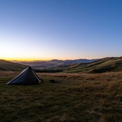 a tent is set up on a hill at sunset