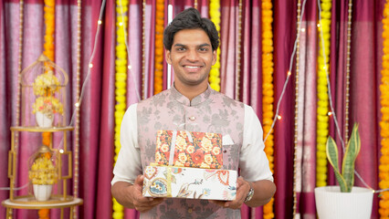 Fototapeta premium Happy Indian Man Holding Gift Boxes on Diwali Festival