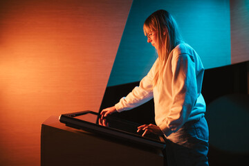 Adolescent girl using touch screen display, skillfully searching interactive content on the modern...