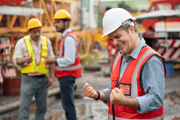 Cheer Mature caucasian engineer man worker with team and spare crane background	