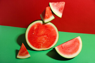 Pieces of fresh watermelon with half on colorful background