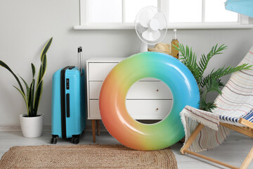 Inflatable ring, suitcase and deck chair in living room